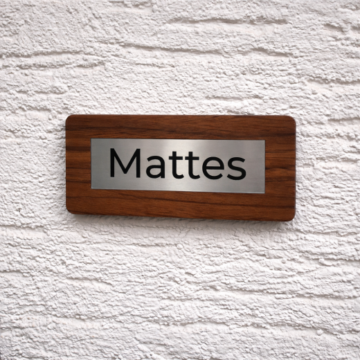 Hochwertige, personalisierte Namensschilder aus massivem Walnussholz mit eingelassenem Inlay aus Acryl in gebürsteter Edelstahloptik und präziser Gravur. Die natürliche Holzstruktur verleiht jedem Schild eine edle und moderne Ausstrahlung und macht es zu