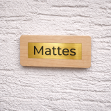 Hochwertige, personalisierte Namensschilder aus massivem Ahornholz mit eingelassenem Inlay aus Acryl in gebürsteter Goldoptik und präziser Gravur. Die natürliche Holzstruktur verleiht jedem Schild eine edle und moderne Ausstrahlung und macht es zu