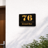 Elegantes Hausnummernschild aus schwarzem Acryl mit hochwertiger Spiegelglas-Optik in Gold. Wetterfest, langlebig und individuell gefertigt – ideal für moderne Hausfassaden.